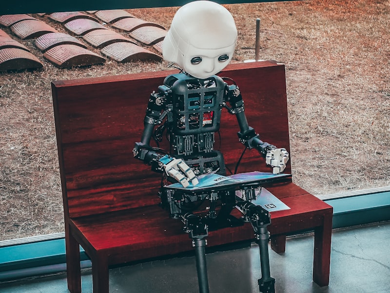 Small humanoid robot seated on a bench