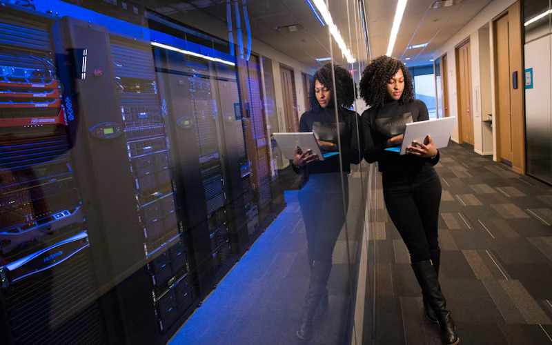 Illustrative view of people working beside server racks