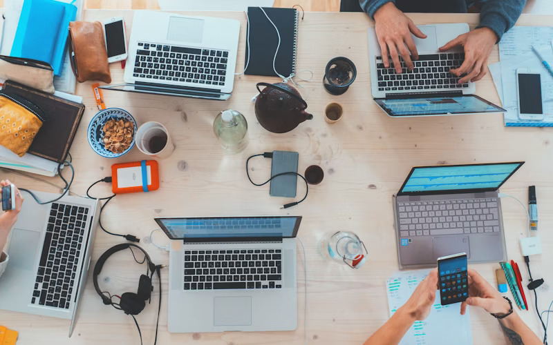Illustrative overhead view of a shared workspace with laptops